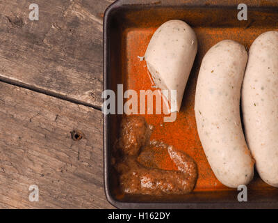 Leckere bayrische Weißwürste mit süßem Senf in einem rustikalen Keramikschale Stockfoto