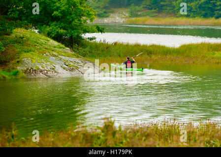 Sundsby, Schweden - 9. September 2016: Reisedokumentation der Mann Paddeln auf ruhigen Wald Wasser einen leicht nebligen Tag im ea Stockfoto