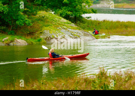 Sundsby, Schweden - 9. September 2016: Reisedokumentation Frau Paddeln auf ruhigen Wald Wasser einen leicht nebligen Tag im Stockfoto