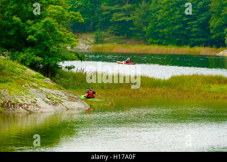 Sundsby, Schweden - 9. September 2016: Reisedokumentation der Mann Paddeln auf ruhigen Wald Wasser einen leicht nebligen Tag im ea Stockfoto