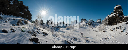 Frau auf der Spur in der schneebedeckten Landschaft, Sonnenschein, Lavafeld mit Schnee bedeckt, Krafla vulkanischen System, Dimmuborgir Nationalpark Stockfoto