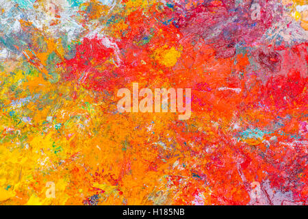 Bunte abstrakte Muster aus getrockneter Ölfarbe auf einer Fläche von Palette des Künstlers. Helle und freundliche Farben. Rot, purpurrot Stockfoto