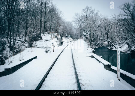 Eine schneebedeckte Bahngleis und Creek im ländlichen Carroll County, Maryland. Stockfoto