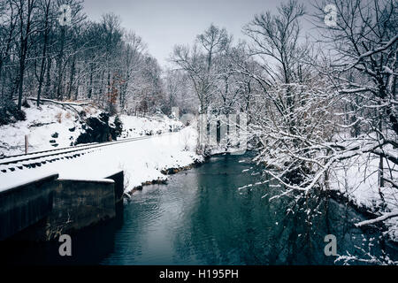 Eine schneebedeckte Bahngleis und Creek im ländlichen Carroll County, Maryland. Stockfoto