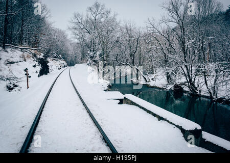 Eine schneebedeckte Bahngleis und Creek im ländlichen Carroll County, Maryland. Stockfoto