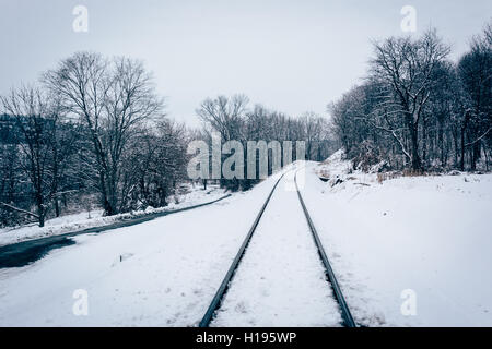 Schneebedeckte Bahngleis und Straße in Baltimore County, Maryland. Stockfoto
