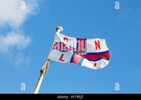 RNLI (Royal National Lifeboat Institution) Flagge am Fahnenmast vor blauem Himmel, Norfolk, Großbritannien Stockfoto