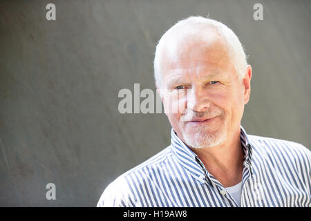 Ältere Menschen vor einer grauen Wand Stockfoto
