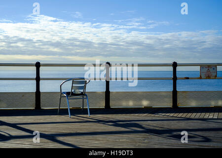 "Nach der Tea'. Eine leere Tasse sitzt auf einem leeren Stuhl, Blick auf das Meer von Worthing Pier.  23.09.2016 in Worthing Beach, Worthing. Bild von Julie Edwards. Stockfoto