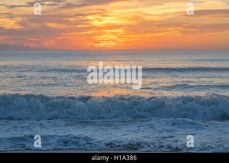 Ein bewölkter Himmel schafft einen herrlich bunten Sonnenaufgang in Satellite Beach, Florida Stockfoto