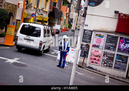 Ein Bauarbeiter leitet den Datenverkehr in Tokio, Japan Stockfoto