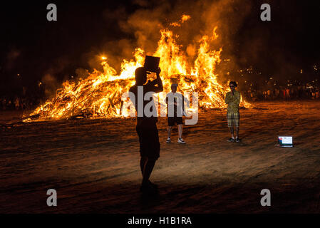 Junge Menschen tanzen Feiern der hl. Johannes Eve (Sant Joan) rund um ein Lagerfeuer am Strand von Estartit, Costa Brava, Katalonien, Spanien. Stockfoto