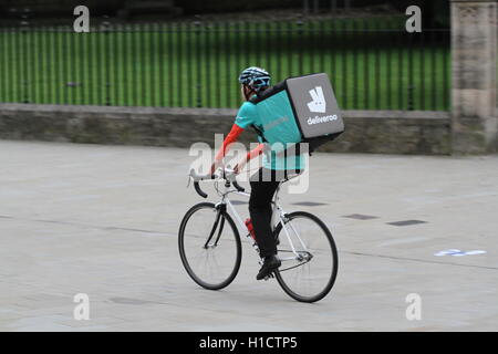 Deliveroo Radfahrer aus dem beliebter heiße Nahrung und Fast Food Lieferung Unternehmen Fahrrad durch die Straßen der Stadt. Stockfoto