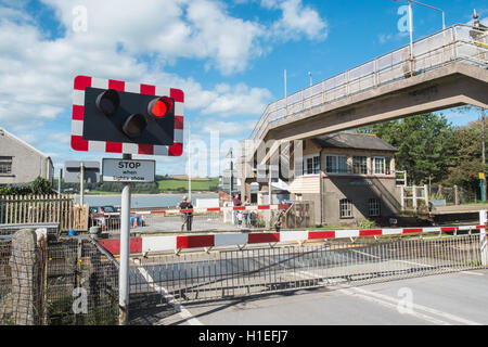 Arriva Zug vorbei Schranke eines Bahnübergangs am Ferryside Dorf Bahnhof, Carmarthenshire, West Wales,U.K.,GB,Europe. Stockfoto