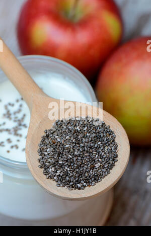 Chia-Samen in Kochloeffel Auf Joghurtglas Und Aepfel, Salvia hispanica Stockfoto