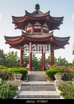 Leute sitzen unter einer Pagode auf dem Gebiet der großen Wildgans-Pagode befindet sich in Xian Stockfoto