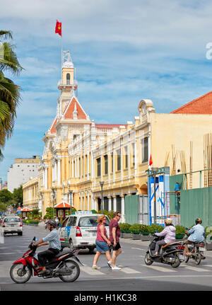 Touristen, die die belebte Straße Le Thanh Ton in der Nähe Des People's Committee Building überqueren. Ho-Chi-Minh-Stadt, Vietnam. Stockfoto