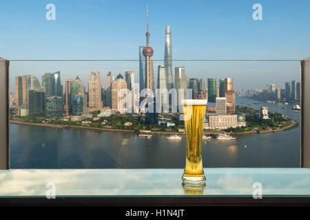 Bier und Schaum Bier am Tisch in der Bar auf der Dachterrasse mit Shanghai Hochhaus im Hintergrund in Shanghai, China. Sicht von Shanghai, Chi Stockfoto