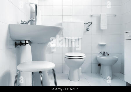 Schwarz / weiß Bild einer Toilette mit WC, Bidet, Waschbecken und einem kleinen Hocker Stockfoto