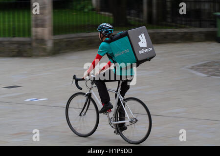 Deliveroo Radfahrer aus dem beliebter heiße Nahrung und Fast Food Lieferung Unternehmen Fahrrad durch die Straßen der Stadt. Stockfoto