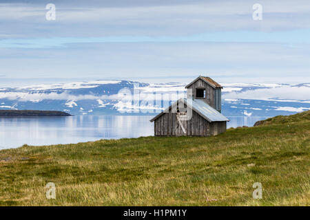 Einsames Haus steht auf einem Fjord in Island Stockfoto