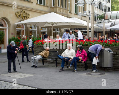 Straßenszene in der Stadt Zentrum von Köln, Deutschland, mit Mann seinen Kopf in eine Mülltonne zu stecken. Stockfoto