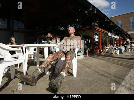 Colin Snow sonnt sich während der London International Tattoo Convention in Tobacco Dock in London. Stockfoto