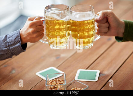 Nahaufnahme von Händen Klirren Bierkrüge in Bar oder Kneipe Stockfoto