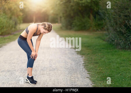 Junge Frau vor dem Training, Übungen Übungen, dehnen sie Muskeln auf einem Feldweg im Morgenlicht Stockfoto