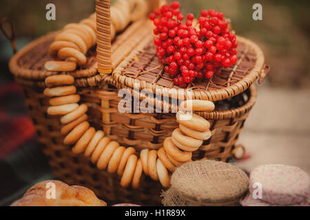 Land-Stillleben. Alten Holztisch mit Marmelade in Gläsern, Weidenkörbe und andere Symbole der Herbst im Garten. Stockfoto