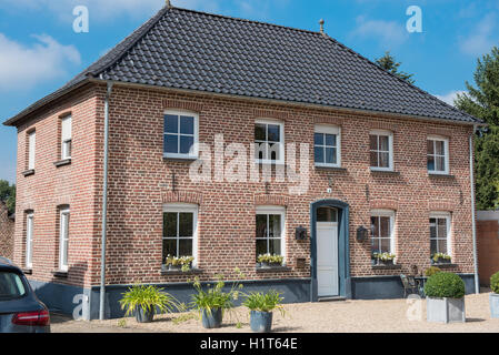 rote Backsteinhaus mit weißen Fenstern und weißen Eingang Stockfoto