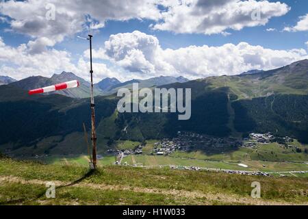 Rot-weiß gestreiften Windsack dramatische Wolken Berge im Hintergrund Stockfoto
