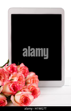 Tablet und Strauß rosa Rosen auf weißem Hintergrund. Platz für text Stockfoto