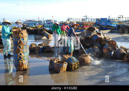 Lagi, Vietnam - 26. Februar 2012: Einheimische Frauen sind ihre Körbe reinigen die verwendet wurden, für den Transport von Fischen vom Boot Stockfoto