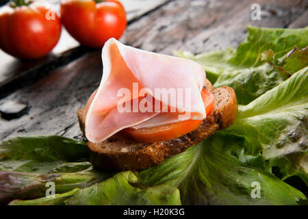 Bruschetta mit Tomaten auf eine Brotscheibe auf Holzbrett und Schweineschinken Stockfoto