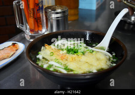 Essen im japanischen Stil Kake Udon japanische Nudeln oder Nudelsuppe mit Garnelen-Tempura und gebratenem Lachs Fisch zum Verkauf inmitten restau Stockfoto