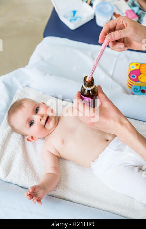 Mutter gibt ihr 6 Monate altes Baby Mädchen Doliprane mit einer Pipette. Stockfoto