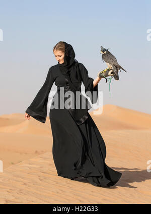 Emiratischen Frau im traditionellen emiratischen Kleid (Abaya) mit einem Falken Stockfoto