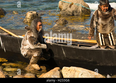 Europa, Grönland, Kujalleq Gemeinde, Nanortalik (Ort der Eisbären), Inuit-Mann/Frau in traditioneller Kleidung mit Kajak Stockfoto