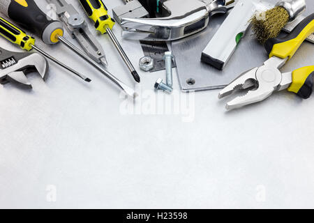 Verkratzte Metall Hintergrund mit gelben Werkzeugsatz und Instrumente für Handarbeit und Befestigung Stockfoto