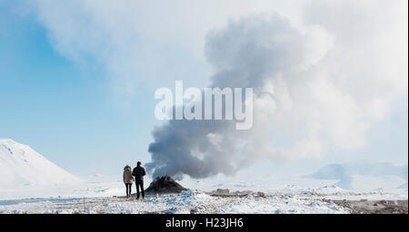 Zwei Touristen stehend neben dampfenden Fumarole, Solfatara in Hverarönd, auch Hverir oder Namaskard, geothermale Region Stockfoto