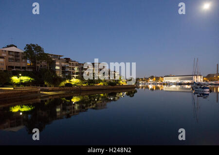 Sonnenaufgang und Mond über Apartments am Wasser auf Black Wattle Bay Glebe Sydney Australia Stockfoto