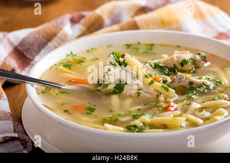 Huhn-Nudelsuppe in weiße Schüssel mit Löffel Stockfoto