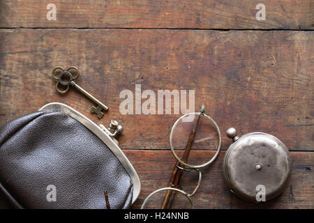 Alte Brille in der Nähe von Taschenuhr und Brieftasche auf hölzernen Hintergrund Stockfoto