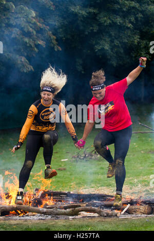 Freunde halten sich an den Händen springen Brand an Bear Grylls Überleben der Rasse, Tatton Park, Knutsford, Konkurrenten, Springen am Feuer springen, nahmen an der BG Outdoor Festival für Großbritannien, das die meisten aufregenden und erlebnisreichen Tag in Cheshire das beeindruckende Tatton Park, mit über 2.000 Hektar großen Wildpark, Meres und Wald. Mit Aktivitäten, Herausforderungen, fantastische Preise, live Musik, gourmet Essen pop-ups & lizenzierte Bars. Es war für die ganze Familie mit Bungee springen, Segway, Parajet flying zeigt, Feuer Beleuchtung, Luftgewehrschießen und vieles mehr. Credit: cernan Elias/Alamy leben Nachrichten Stockfoto