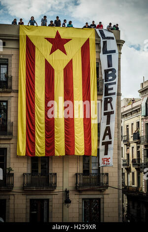 Barcelona, Spanien. 24. September 2016: Pro-Unabhängigkeit Anhänger hängen eine riesige "Estelada" Flagge an der Fassade eines Gebäudes mit Blick auf die St. Jaume Platz anspruchsvoll "Freiheit" lokalen "Castellers" tagsüber an Merce 2016 Credit: Matthi/Alamy Live-Nachrichten Stockfoto