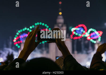 Moskau, Russland. 24. Sep, 2016. Eine Person nimmt Bilder von Handy während einer Licht-Show vor Moskau Landesuniversität in Moskau, Russland, am 24. September 2016. Der Kreis des Lichts Moskau internationale Festival ist eine jährliche Veranstaltung, die an der Lichtplaner und Spezialisten für audiovisuelle Kunst aus verschiedenen Ländern neu die Architekturszene von Moskau erfinden über video Mapping. Bildnachweis: Bai Xueqi/Xinhua/Alamy Live-Nachrichten Stockfoto