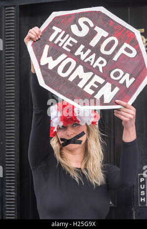 London, UK. 24. Sep, 2016. Ein polnischer feministische steht mit ihrem Mund versiegelt mit schwarzem Klebeband mit einem Schild "Stop Krieg gegen Frauen" bei der Protest in der polnischen Botschaft in Solidarität mit der 5. jährlichen März zur Wahl in Irland gegen die strengen Anti-Abtreibung Gesetze es verurteilt von der UNO als "grausame, unmenschliche und erniedrigende". In Polen MPs in das konservative Recht und Gerechtigkeit (PiS) Partei unterstützen einen Gesetzentwurf vorgelegt von der Lobby der Abtreibung zu stoppen, die Abtreibungen außer wo das Leben der Mutter gefährdet geahndet wird, 3 bis 5 Jahre im Gefängnis war machen würde. Bildnachweis: Peter Marshall/Alamy Live Ne Stockfoto