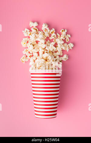 Popcorn in Papierschale auf farbigen Hintergrund. Stockfoto