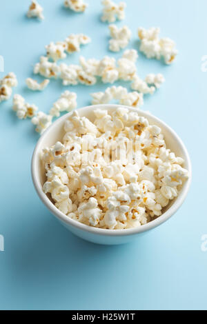 Popcorn in Schüssel auf blauem Hintergrund.
